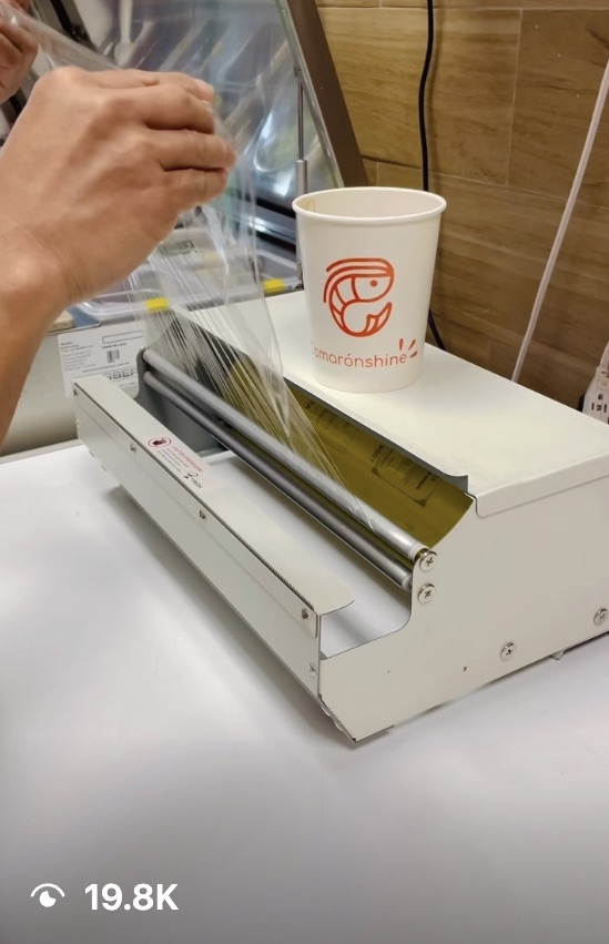 Reel still: a branded Camarónshine cup being sealed with plastic wrap, 19.8K views
